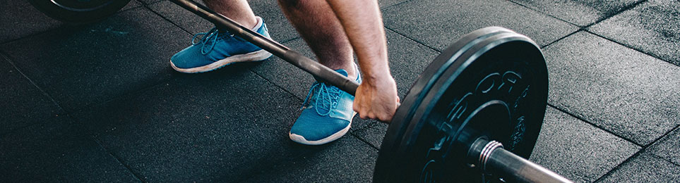 Athlet beim Kreuzheben mit Langhantel auf einem professionellen Stemmboden – ideale Ausstattung für effektives Gewichtheben-Training.