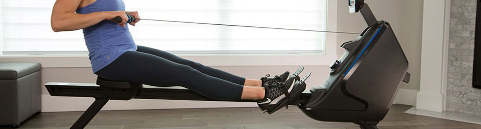 Sportlerin trainiert auf einem Rudergerät