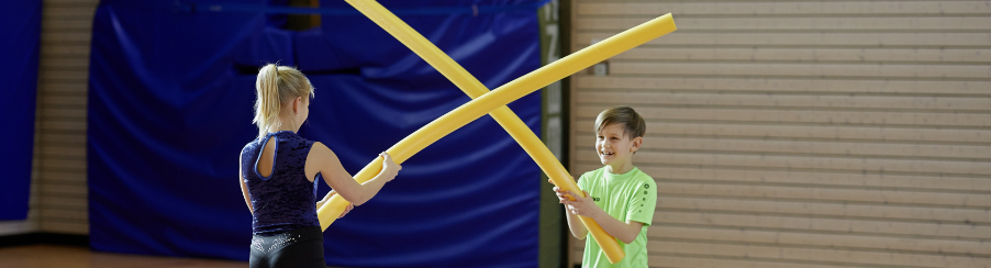 Kinder und Erwachsene spielen mit Materialien zum Aggressionsabbau in einer Therapiegruppe