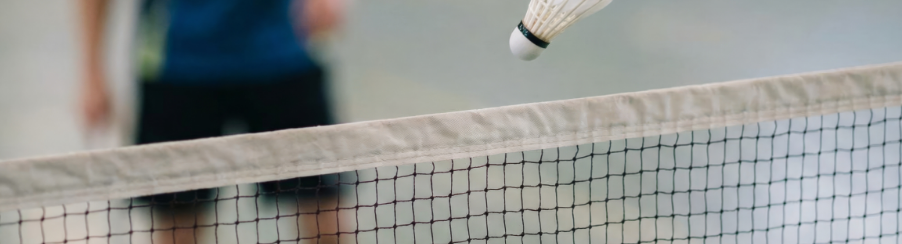 Ein aufgebautes Badminton Netz auf einem Spielfeld in der Halle mit Racketsport-Ausstattung