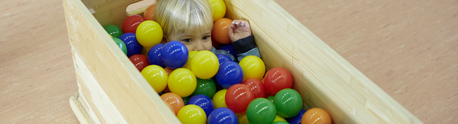 Kinder spielen gemeinsam in einem bunten Bällebad zur Förderung von Motorik und Wahrnehmung