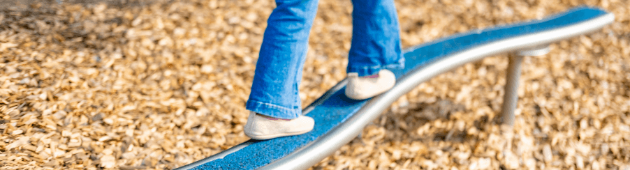 Kinder balancieren auf einem Balancierbalken auf einem Spielplatzgerät