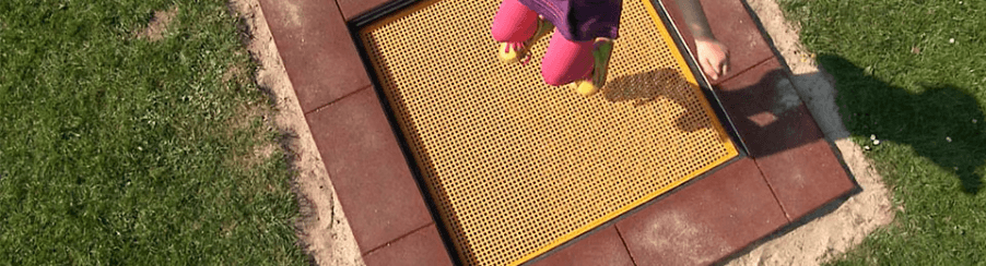 Großes rechteckiges Bodentrampolin mit ebenerdiger Sprungfläche und sicherer Randabdeckung als Spielplatzgerät für Kinder