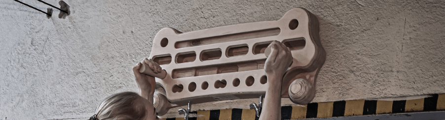 Kletterer trainieren an einem Hangboard für bessere Fingerkraft und Griffkraft