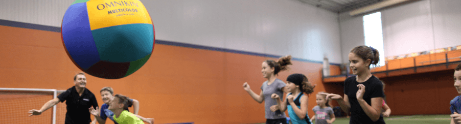 Teamsportgruppen spielen mit einem Kin-Ball in der Halle – jetzt Kin-Ball kaufen bei Kübler Sport