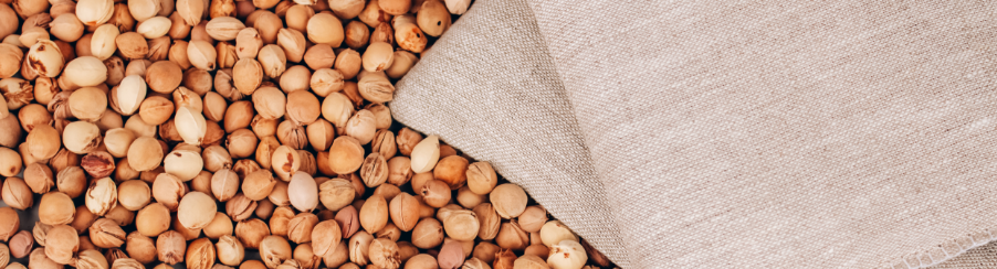 Mehrere Kirschkernkissen aus natürlichen Materialien für die Wärmetherapie im Therapiebedarf, nebeneinanderliegend auf hellem Hintergrund