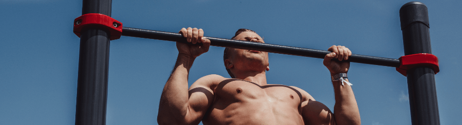 Fitnessbegeisterte trainieren mit Outdoor Klimmzugstange im Garten oder Fitnessbereich