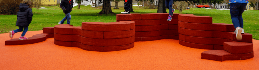 Modernes Parkmobiliar mit Sitzgruppen, Abfallbehältern und Bänken auf einem Spielplatz