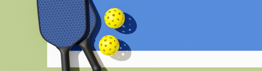 Zwei Pickleball Schläger mit gelochtem Ball vor Netz auf Feld, geeignet für Racketsport