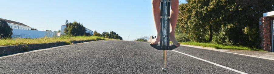 Kinder und Erwachsene hüpfen gemeinsam mit Pogo Sticks im Freien und erleben aktiven Freizeitspaß