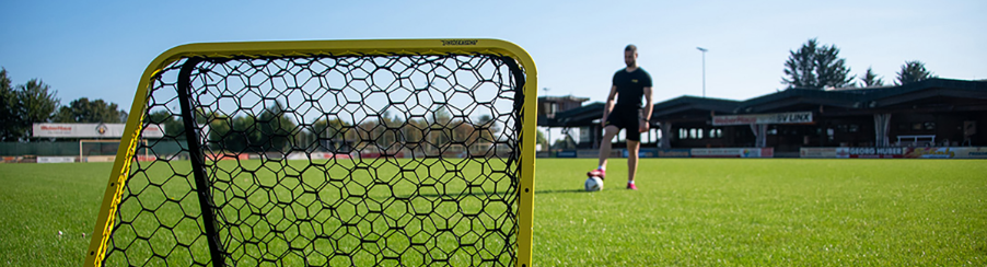 Mehrere Rebounder Fußball für Fußballtraining im Vereinsbedarf auf einem Sportplatz mit Spielern