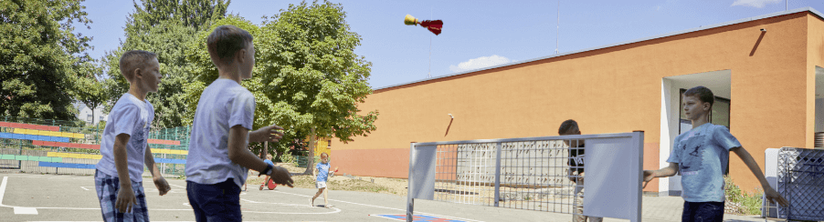 Kinder auf dem Schulhof mit verschiedenen Rückschlagspielen für Freizeitspaß und alle Altersgruppen