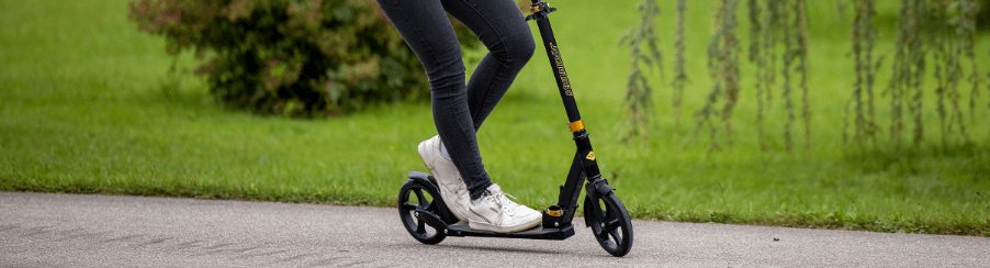 Kinder und Jugendliche nutzen Roller Scooter beim Freizeitspiel auf dem Spielplatz