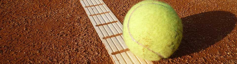 Verschiedene Tennisbälle für Training, Freizeit und Wettkampf auf einem Tennisplatz