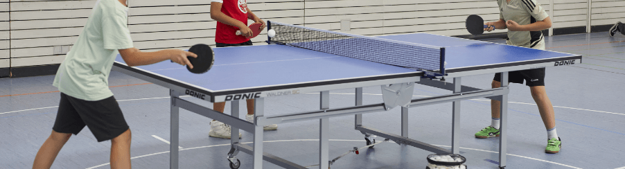 Klappbare Tischtennisplatte mit rollbarem Untergestell und Netz beim Einsatz im Sportverein