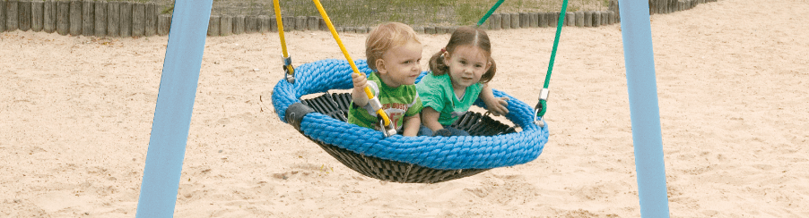Große Vogelnest Schaukel mit mehreren Kindern auf einem Spielplatzgerät im Außenbereich