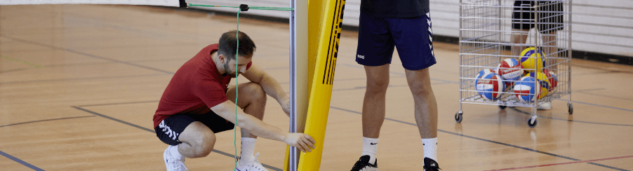 Volleyball Netz, Bälle, Knieschoner und Trainingszubehör für Teamsport auf einem Spielfeld