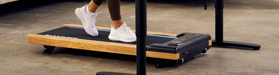 Fitnessbegeisterte Person trainiert mit einem Walking Pad im modernen Wohnraum