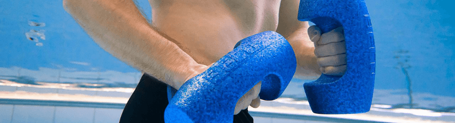 Zwei Personen trainieren im Schwimmbecken mit Wasserhanteln während einer Aquafitness-Einheit